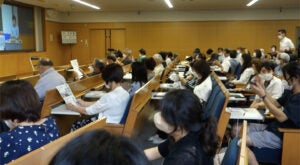 A side view of rows of attendees in the lecture hall in Kyoto Japan.
