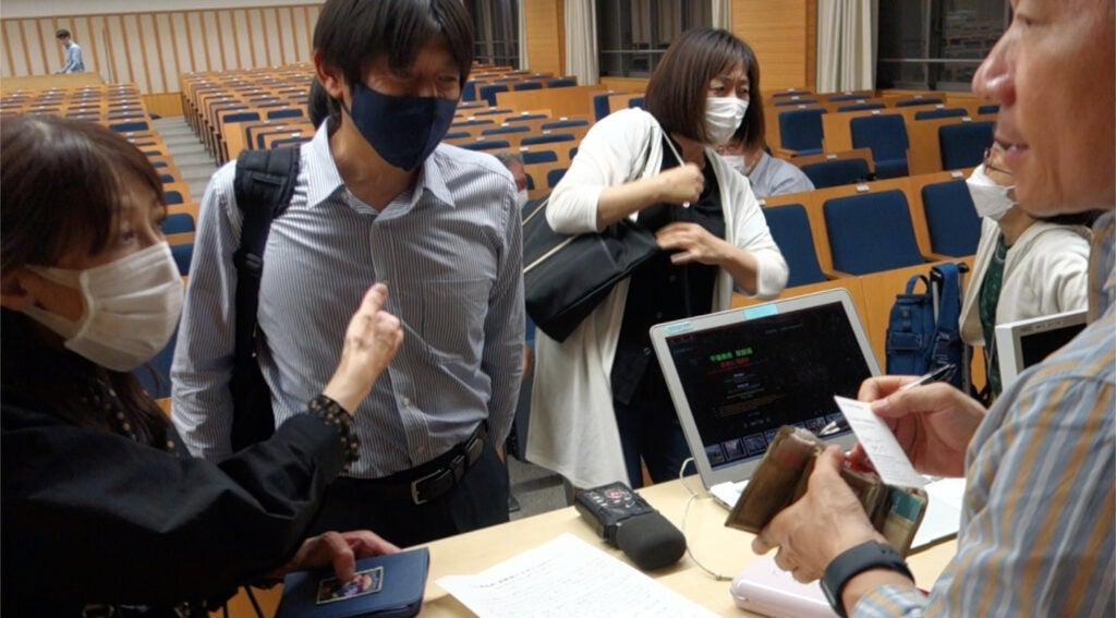 Professor Muhn speaking with a reporter after his talk at Doshisha University.
