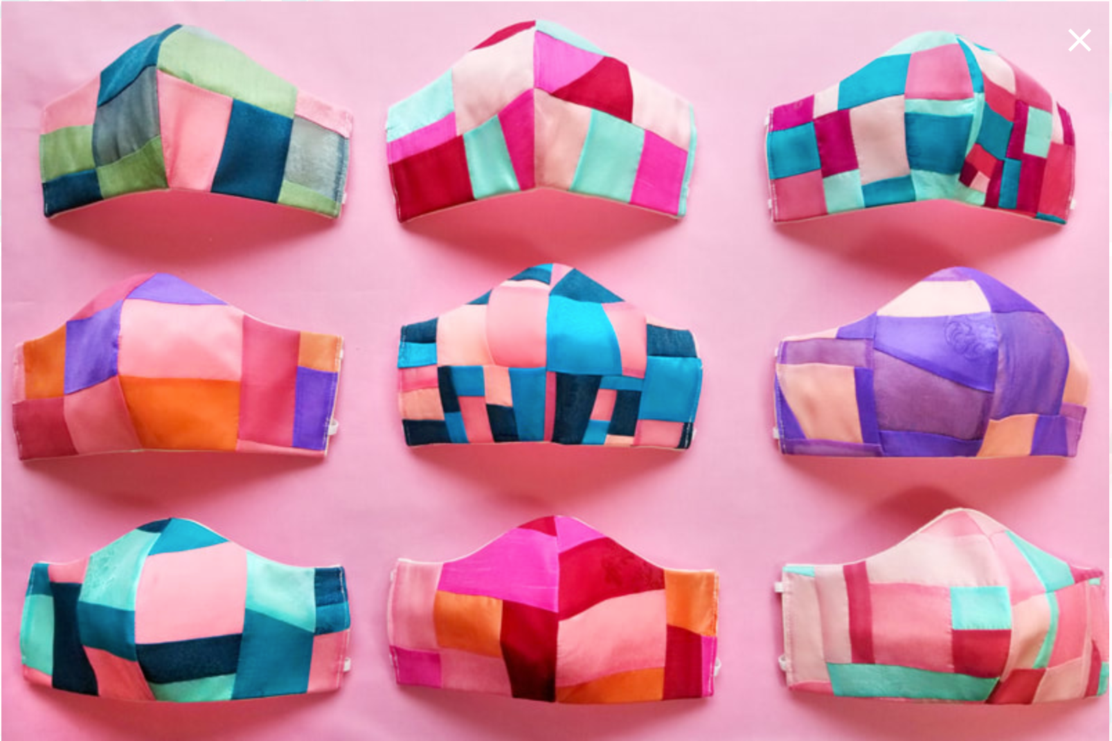 A three by three grid of nine masksk, each a colorful patchwork of fabrics, set on abright pink background.