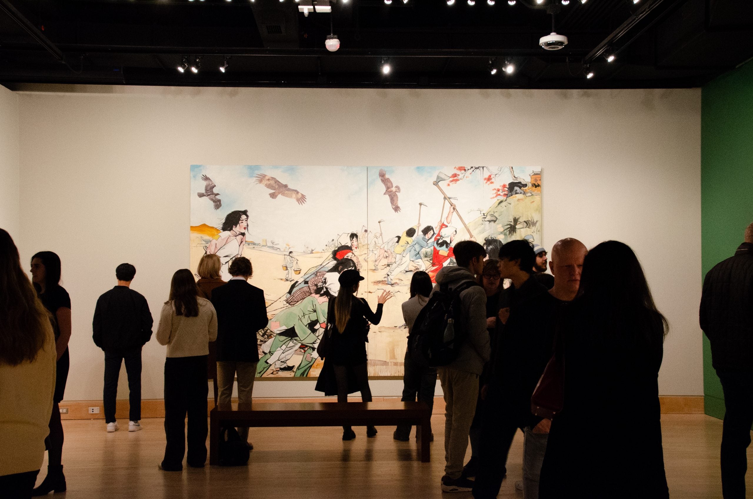 A group of vivistors stands in front of one of the large Hung Liu paintings during the show's opening.